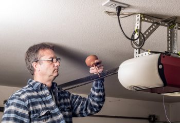 Homeowner applies a little lubricating oil to the chain on his garage door opener
